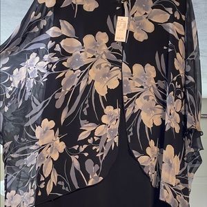 this dress is sleeveless with attached over piece that connects in front also.